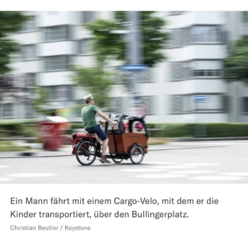 Ein Mann fährt mit einem Cargo-Velo, mit dem er Kinder transportiert, über den Bullingerplatz