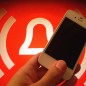 Rotes Alarmlogo mit weissem iPhone 4 im Vordergrund
